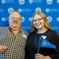 Two alumni pose for a photo